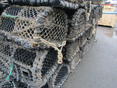 Black lobster pots stacked up on a harbour